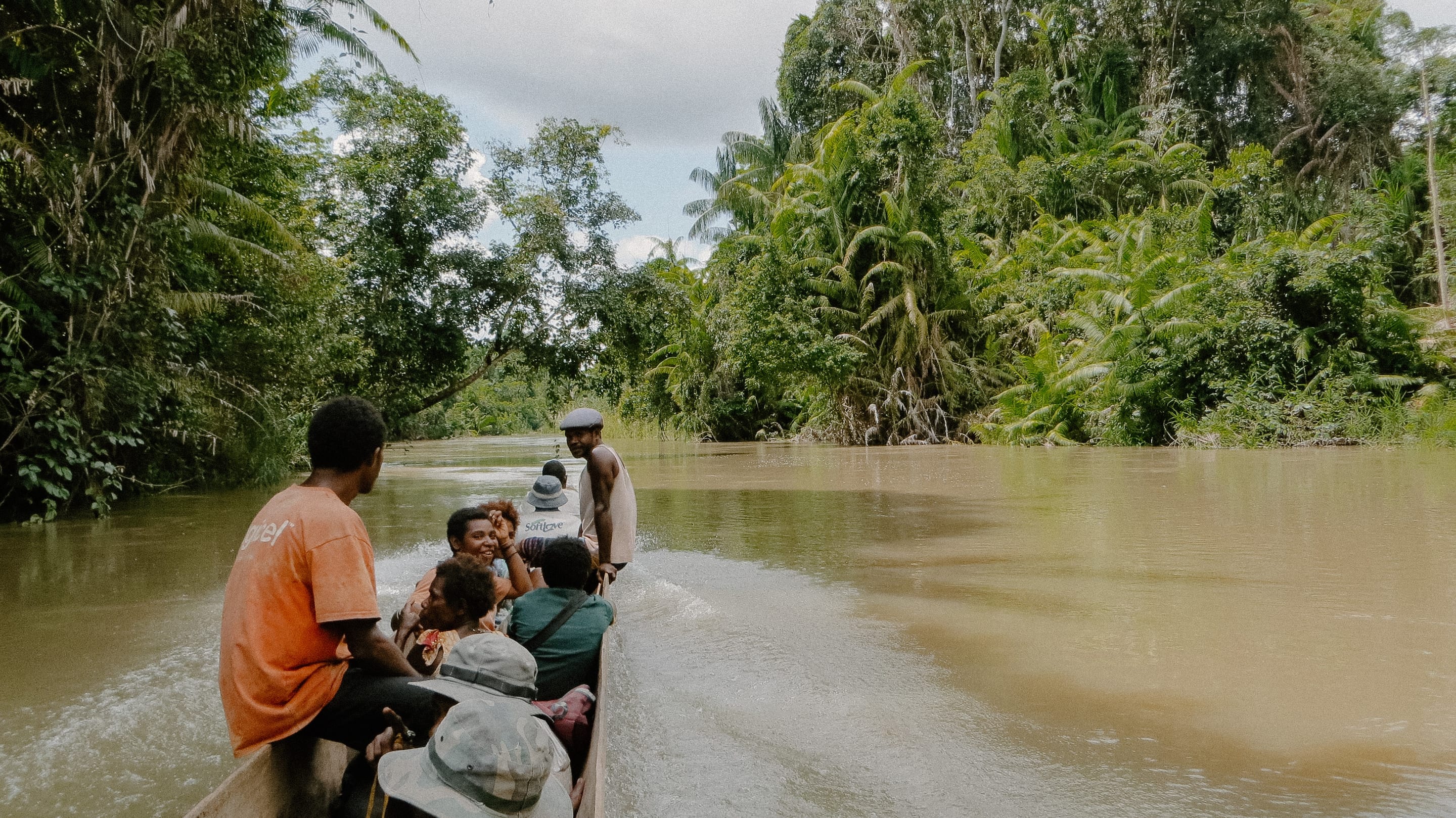 Villagers travelling by dugout canoe on a jungle river
