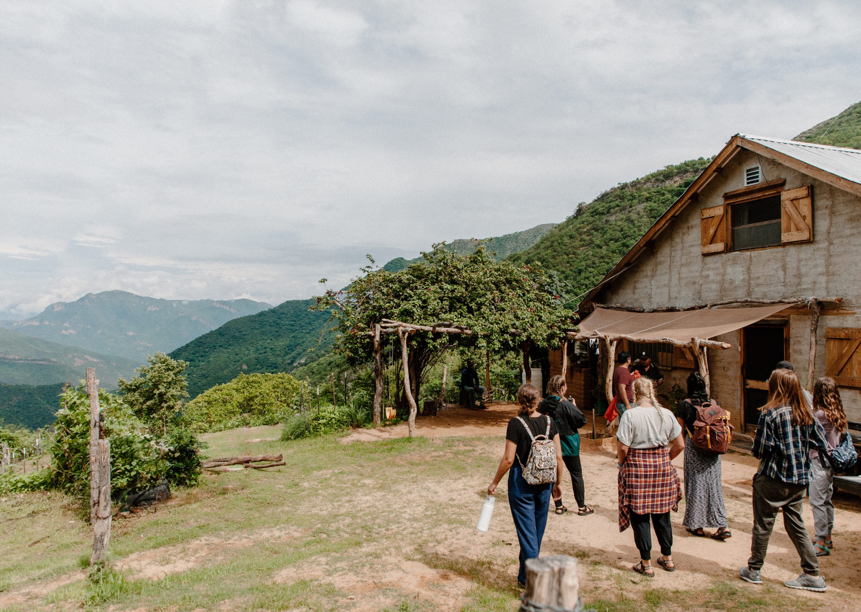 A short-term team walking toward a mountainside mission house